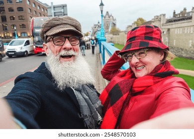 Happy senior couple taking selfie in london - Travel and joyful elderly lifestyle concept - Main focus on man face - Powered by Shutterstock