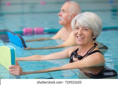 happy senior couple taking swimming lessons