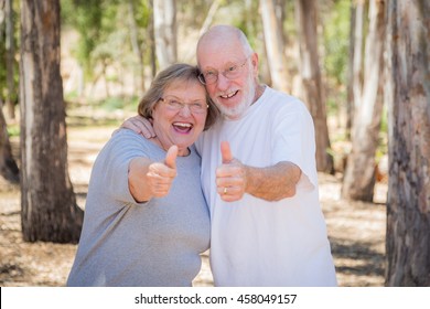 Happy Senior Couple With Thumbs Up Outdoors.
