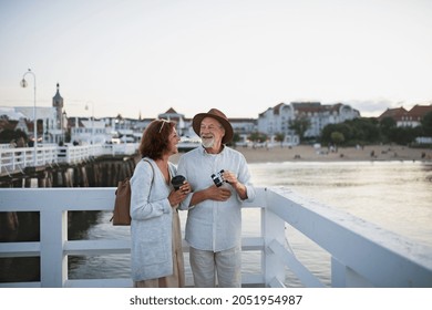 Happy senior couple tourist having fun on walk outdoors on pier by sea, summer holiday. - Powered by Shutterstock