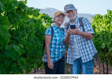 Happy senior couple of tourists in Tenerife travel visiting a vineyard walking amongst grapevines. People on holiday wine tasting experience in summer valley landscape. - Powered by Shutterstock