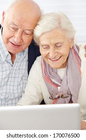 Happy Senior Couple Using Social Media With Laptop Computer