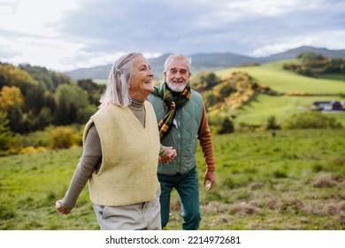 Happy senior couple walking in autumn meadow. - Powered by Shutterstock