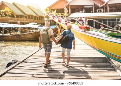 Happy Senior Couple Walking Holding Hand At Koh Panyi Muslim Floating Village - Active Elderly And Travel Lifestyle Concept With Retired Mature People At Phang Nga Bay Thailand - Warm Day Filter