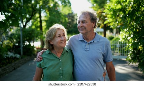 Happy Senior Couple Walking Together In Afternoon Walk