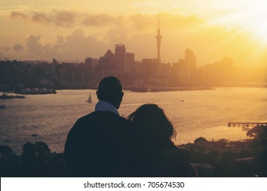 Happy senior couple watching sunset in Auckland, New Zealand.