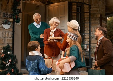 Happy senior couple welcoming their family at doorstep on Thanksgiving.  - Powered by Shutterstock