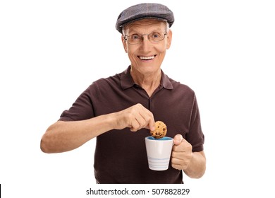 Happy Senior Dipping A Cookie In A Cup Isolated On White Background