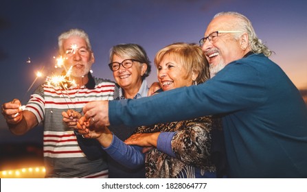 Happy Senior Family Celebrating With Sparkler Fireworks At Home Party - Elderly People Lifestyle And Holidays Concept 