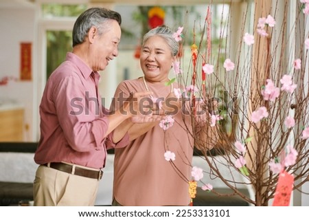 Happy senior family decorating house for Chinese New Year, happy holidays concept
