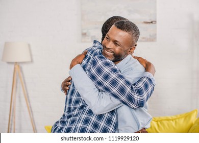 Happy Senior Father And Adult Son Hugging At Home 