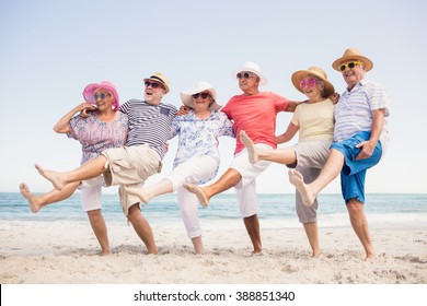 Happy senior friends dancing on the beach - Powered by Shutterstock