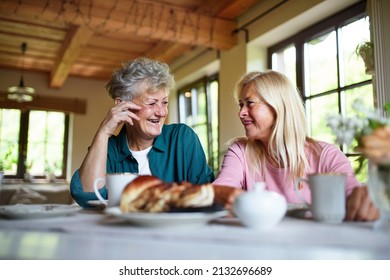 Happy Senior Friends Having Coffee And Cake And Talking Indoors At Home.