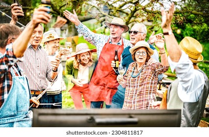 Happy senior friends having fun at picnic barbecue garden diner - Social life style concept with mature people group cooking out at barbeque grill fest - Warm vivid filter with focus on right woman - Powered by Shutterstock