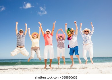 Happy Senior Friends Jumping On The Beach