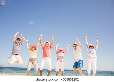 Happy Senior Friends Jumping On The Beach