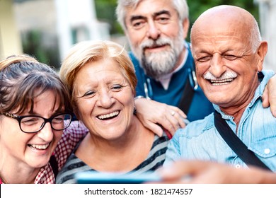 Happy Senior Friends Taking Selfie Around Old Town Street - Retired People Having Fun Together With Mobile Phone - Positive Elderly Lifestyle Concept With Focus On Blond Woman