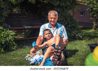 Happy Senior Grandparent Playing With Grandchild On Lawn Concept For Happy Family And Grandparenting  