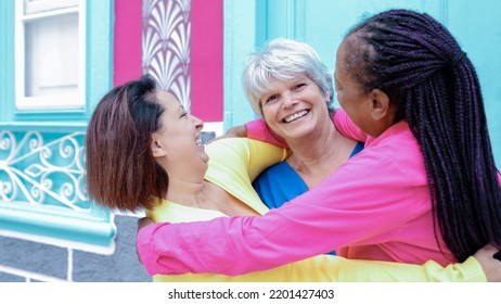 Happy Senior Group Of Friends Hugging Together Outdoor - Diverse Female Community - Focus On Right Woman