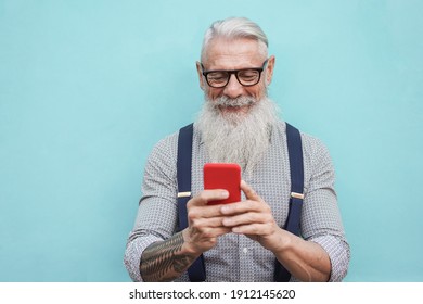 Happy Senior Hipster Man Using Mobile Phone Outdoors In The City - Focus On Face