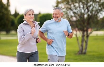Happy senior husband and wife in sportive outfits running outdoors in city park, lovely retirees couple jogging in sunny morning looking at each other with warmth and smile. Healthy lifestyle concept - Powered by Shutterstock