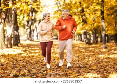 Happy senior husband and wife in sportive outfits running outdoors in city park, lovely retired couple jogging in sunny morning looking at each other with warmth and smile. Healthy lifestyle concept
 - Powered by Shutterstock