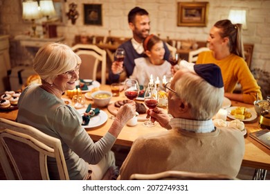 Happy Senior Jewish Couple Toasting With Wine During Family Dinner On Hanukkah.