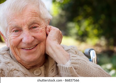 Happy Senior Lady In Wheelchair Smiling Outside