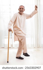 Happy senior man dancing with the walking stick at home (Health and fitness)