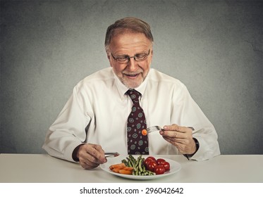 Happy Senior Man Eating Fresh Vegetable Salad 