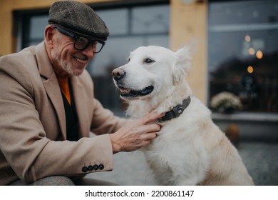 Happy senior man giving collar his dog during walk outdoors in city. - Powered by Shutterstock