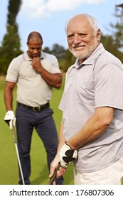 Happy senior man golfing, smiling.
