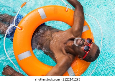 Happy senior man having party in the swimming pool - Active elderly male person sunbathing and relaxing in a private pool during summertime - Powered by Shutterstock