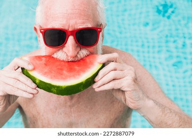 Happy senior man having party in the swimming pool - Active elderly male person sunbathing and relaxing in a private pool during summertime - Powered by Shutterstock