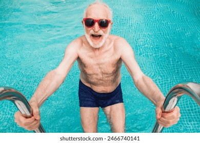 Happy senior man having party in the swimming pool - Active elderly male person sunbathing and relaxing in a private pool during summertime - Powered by Shutterstock