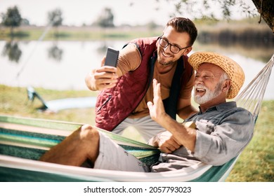 Happy senior man and his son greeting someone via video call while enjoying a day in nature. - Powered by Shutterstock