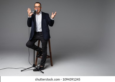 Happy Senior Man Holding A Microphone, Isolated On White