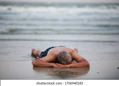 Happy Senior Man Is Lying Down On Sand Beach Ground While Having Vacation At Tropical Beach. Healthy Retirement Old Age Man Enjoying In Summer Holiday Vacation. Rest And Relax On Beach Concept.