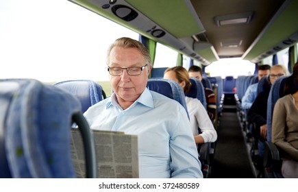 Happy Senior Man Reading Newspaper In Travel Bus