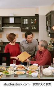 Happy senior man receiving Tet present from his daughter and her husband
