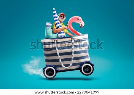 Happy senior man riding a fast bag with wheels and going to the beach, summer vacations at the seaside concept, copy space