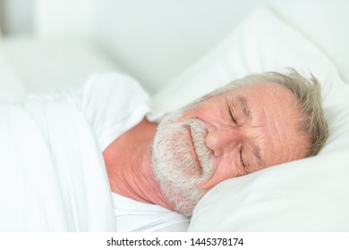 Happy Senior Man Sleeping In Bed.