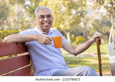 Happy Senior Man With Walking Cane At Park