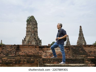 A Happy Senior Man Is Walking Up The Old Bricks Stairs To Visit Ancient Historical Park, Concept Elderly Retired Man Lifestyle,freedom,travel,ecotourism,quality Of Life