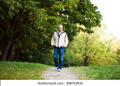 Happy Senior Man Walking And Relaxing In Park