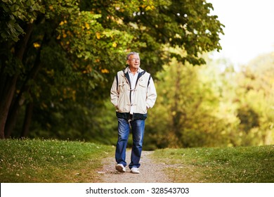 Happy Senior Man Walking And Relaxing In Park