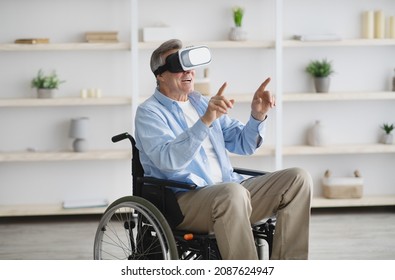 Happy senior man in wheelchair using VR headset to explore augmented reality at home. Mature male with disability playing virtual online game, having fun with contemporary technologies - Powered by Shutterstock