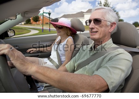 Happy senior man and woman couple driving a convertible car wearing sunglasses, s3niorlife