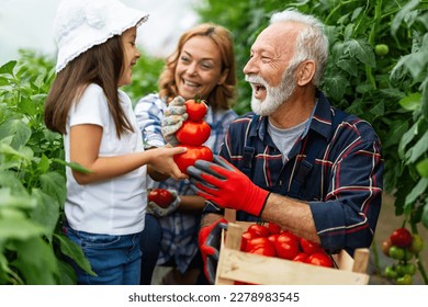 Happy senior man working together with family in greenhouse business. People organic food concept. - Powered by Shutterstock