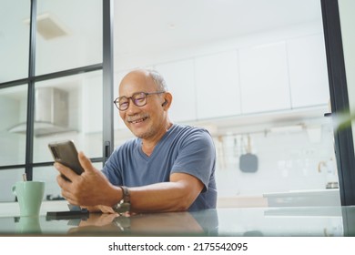 Happy Senior Mature Male Sitting Using Smartphone At Home, Leisure, Active Lifestyle